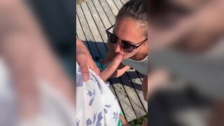 Woman does risky oral porno on the beach